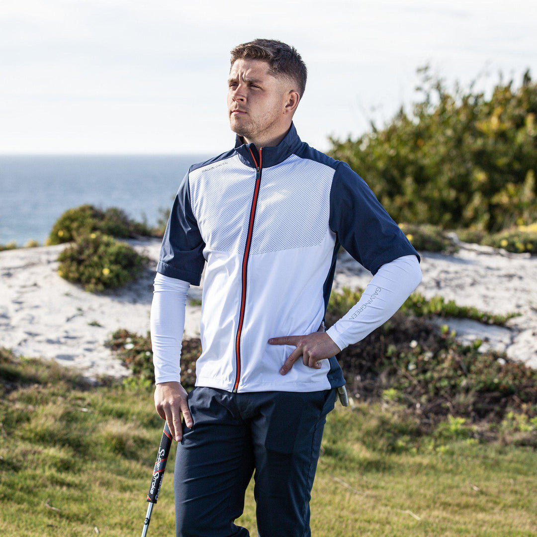 Livingston is a Windproof and water repellent short sleeve golf jacket for  in the color White/Navy/Orange(4)