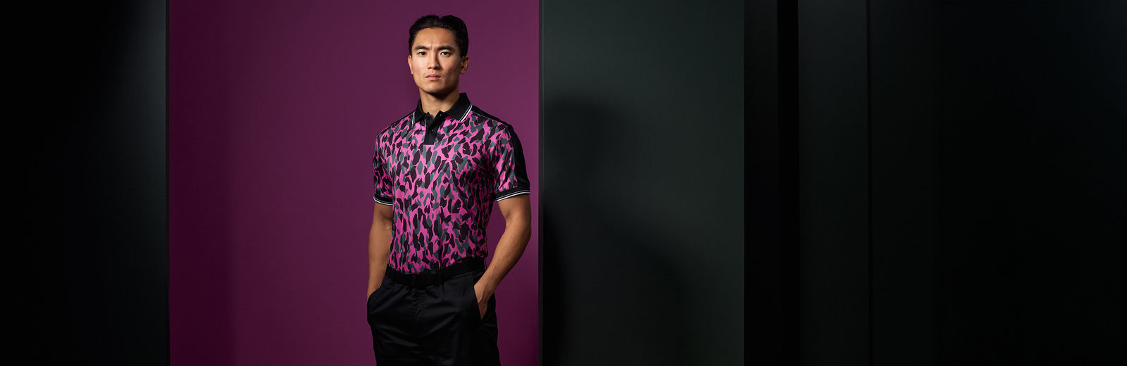Male wearing a cool and trendy pink camo golf polo in breathable material.