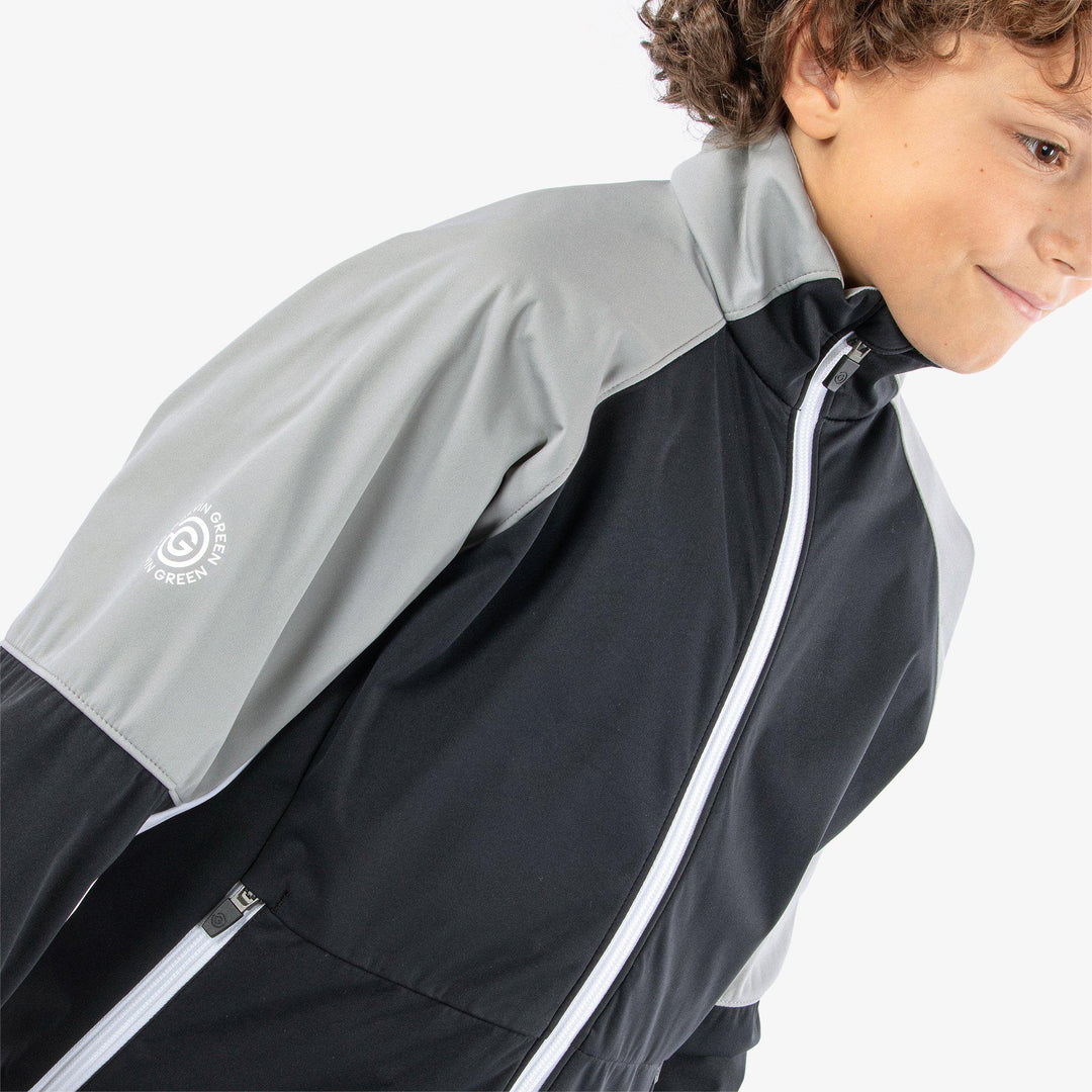 Remi is a Windproof and water repellent golf jacket for Juniors in the color Black/Sharksin/White(5)
